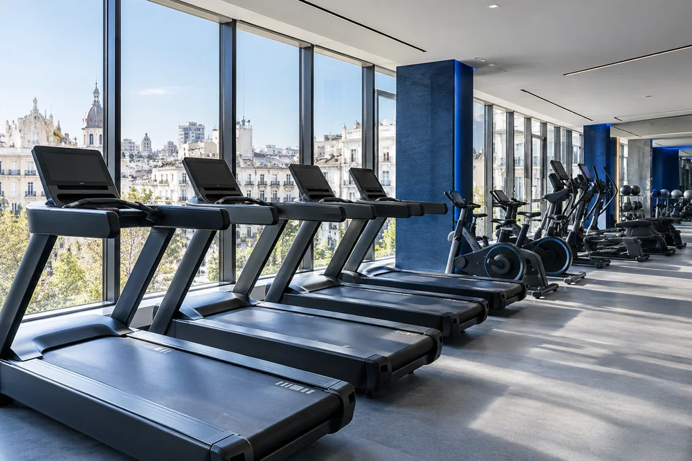 Sala de cardio con cintas, bicicletas y luz natural